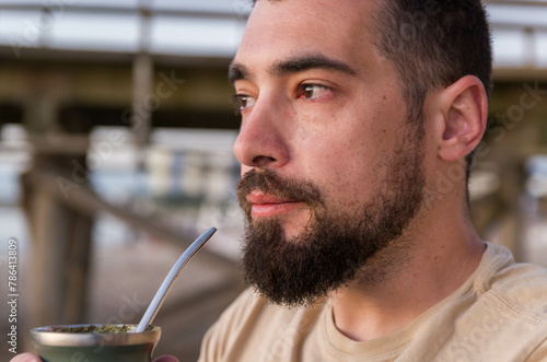 Man drinking chimarrão, mate (an infusion of yerba mate with hot water) at sunset