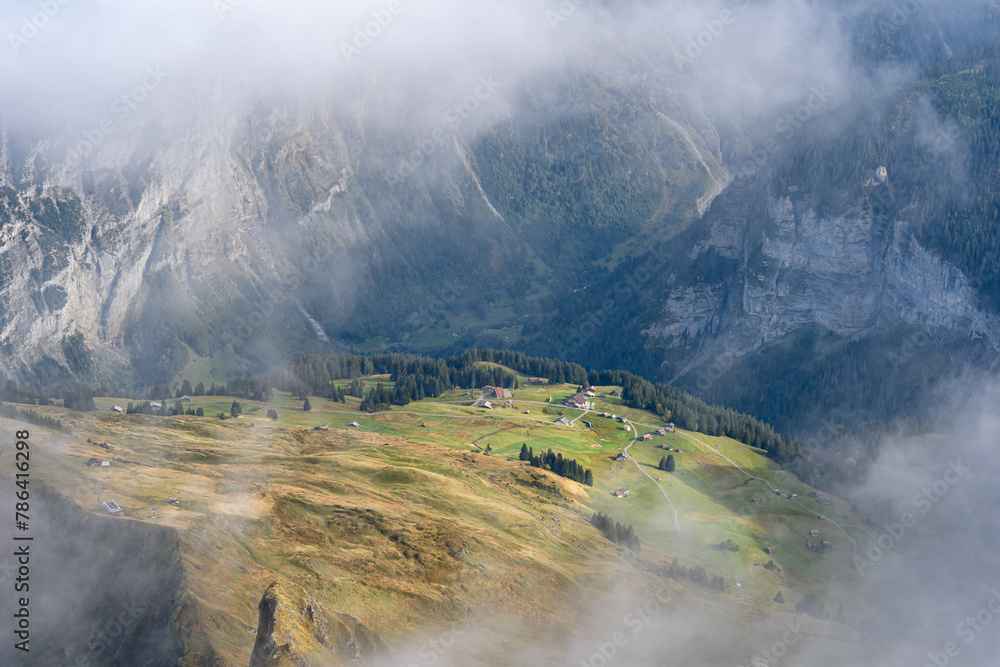 View of Lauterbrunnen valley in Swiss Alps. Bright sunny day with low clouds in Switzerland