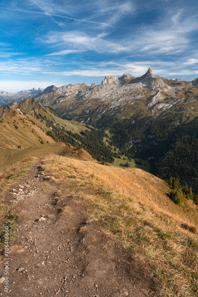 Swiss Alps mountain range seen from summit of Klingenstock, Switzerland. Hiking trail on a ridge