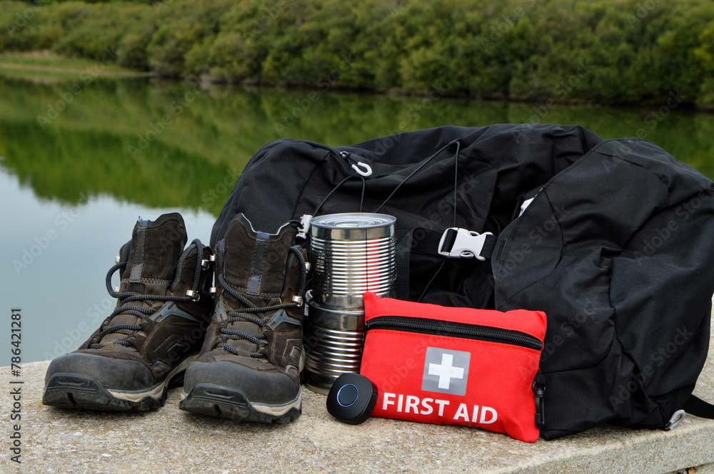 hiking equipment with a backpack, hiking shoes, cans of food, and for safety, a first aid kit and a GPS tracker. hiking equipment with a backpack, hiking shoes, cans of food, and for safety, a first aid kit and a GPS tracker.