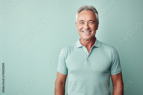 Portrait of a happy man in his 60s wearing a breathable golf polo isolated in modern minimalist interior © Markus Schröder