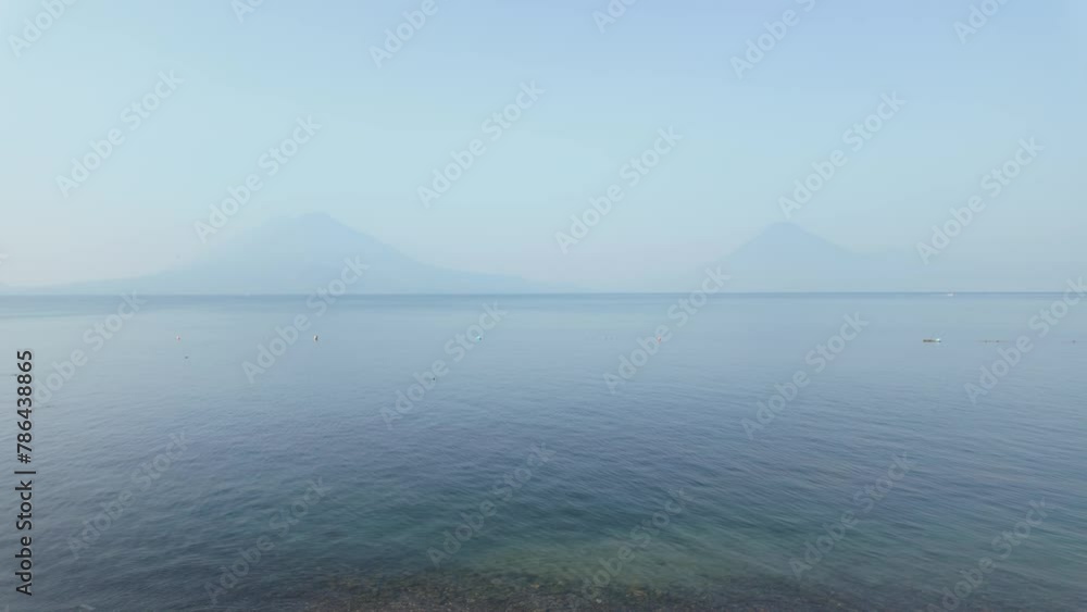 Water taxi moving across lake Atitlan in Guatemala in front of volcanos panorama Water taxi moving across lake Atitlan in Guatemala in front of volcanos panorama