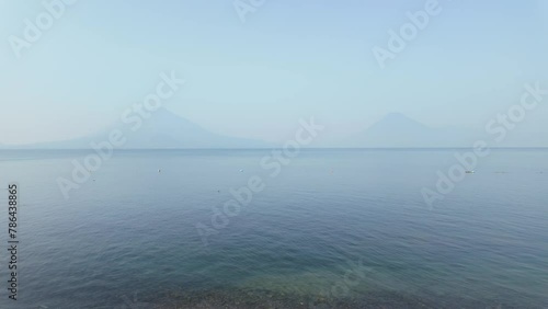 Water taxi moving across lake Atitlan in Guatemala in front of volcanos panorama  photo