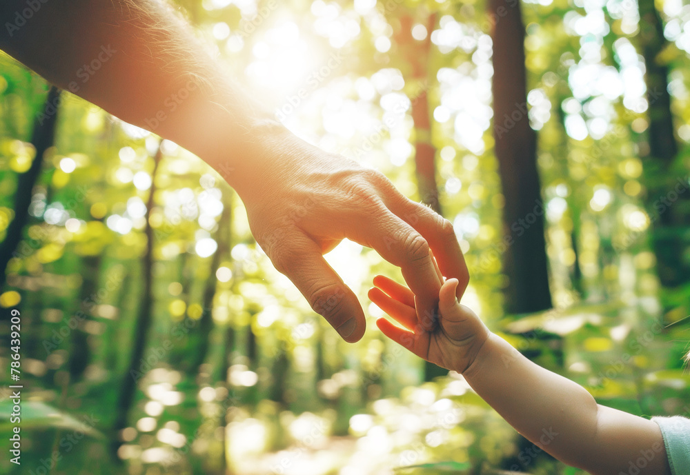 Close up of father holding hand of little daughter on lawn, relaxing and enjoying family bonding time on a lovely day in park. Family love and care. Connection with nature concept Close up of father holding hand of little daughter on lawn, relaxing and enjoying family bonding time on a lovely day in park. Family love and care. Connection with nature concept