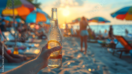 Person holding a soda bottle at the beach at sunset