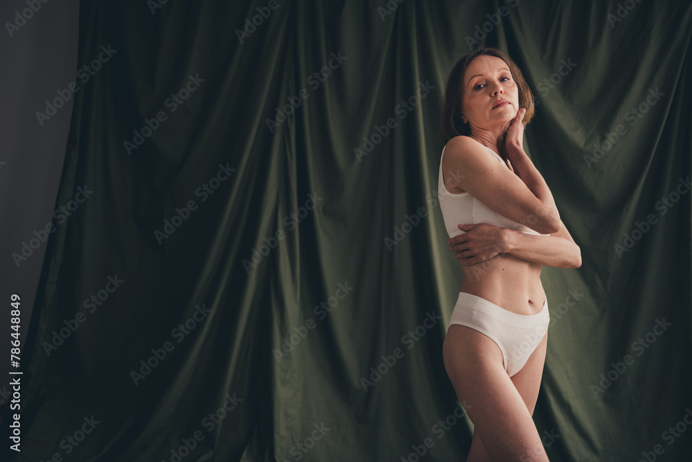 Unretouched photo of old woman touch face posing for photography isolated dark colored linen background Unretouched photo of old woman touch face posing for photography isolated dark colored linen background