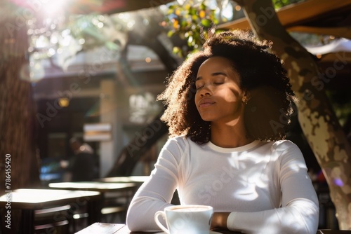 Frau mit Afro-Haar genießt warmes Sonnenlicht,
Woman with Afro Hairstyle Enjoys Warm Sunlight photo