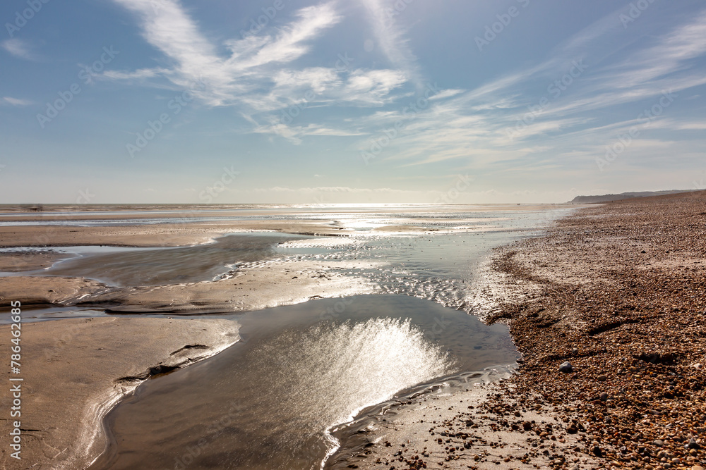 Low tide at Winchelsea Beach in East Sussex, with a blue sky overhead
