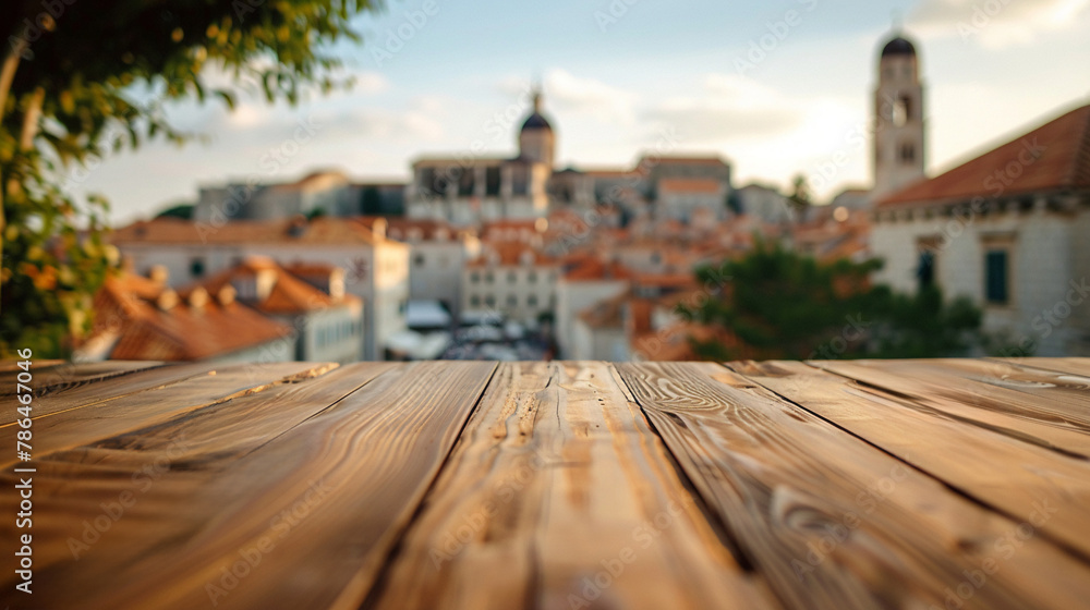 Fototapeta premium Tranquil dining perspective from a wooden table with Dubrovnik's historic architecture softly blurred in the distance
