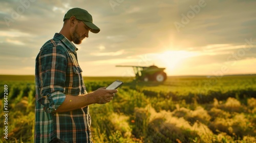 A dynamic shot of a farmer using a mobile device to analyze yield data and plan crop rotations.  photo