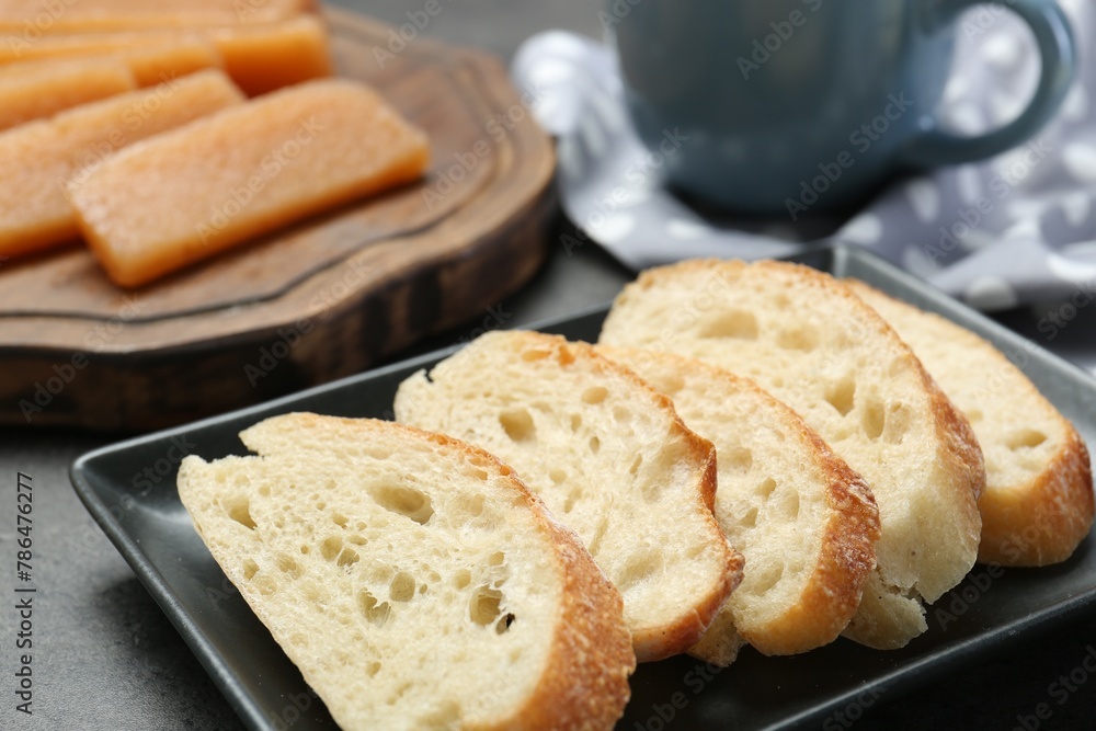 Delicious quince paste and bread on grey textured table, closeup Delicious quince paste and bread on grey textured table, closeup