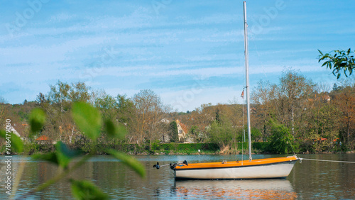 A small boat is on a calm river. During sunset