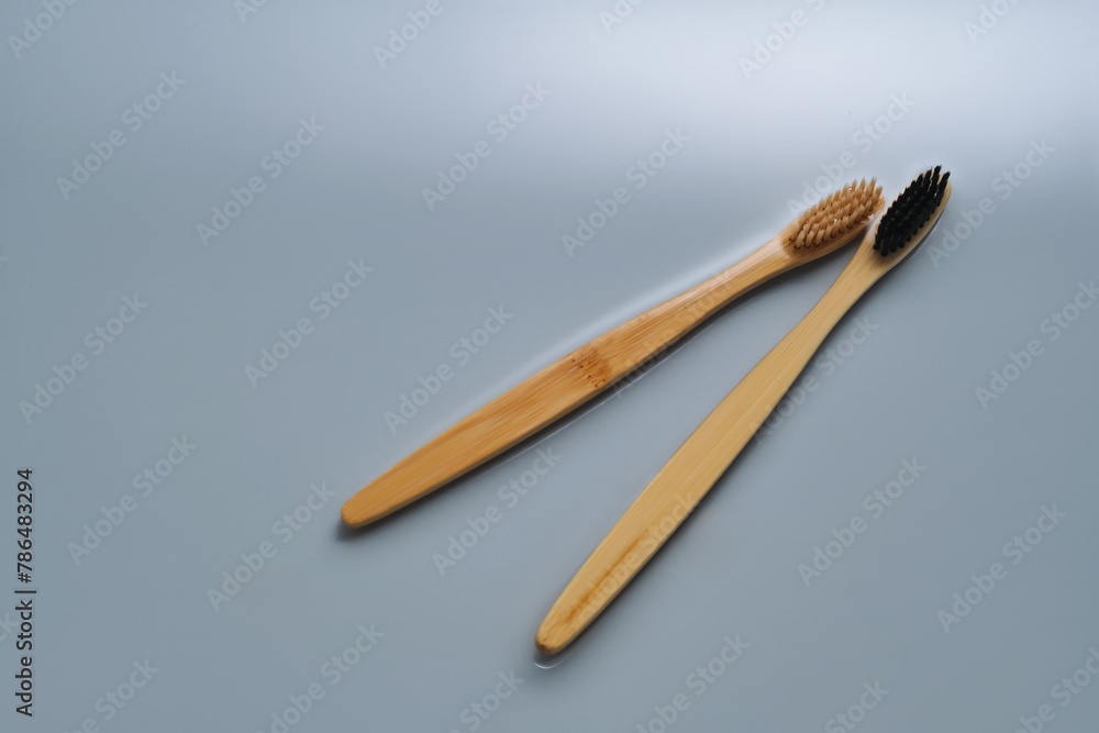 Natural bamboo toothbrushes in water on a blue background. Natural bamboo toothbrushes in water on a blue background.