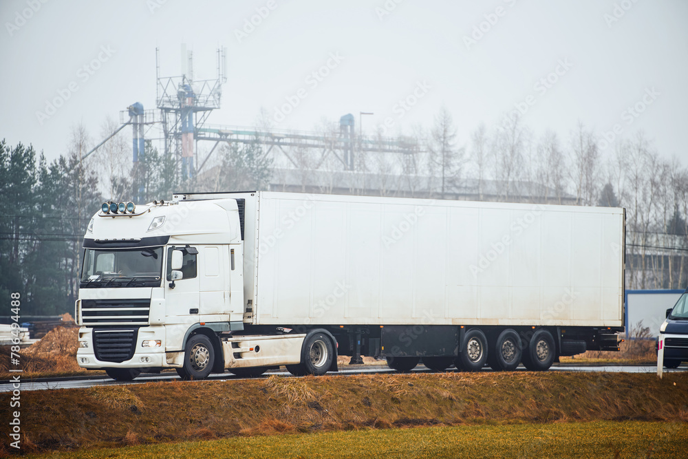 Front View of a Glossy White Truck Carrying Cargo on the Open Road Front View of a Glossy White Truck Carrying Cargo on the Open Road