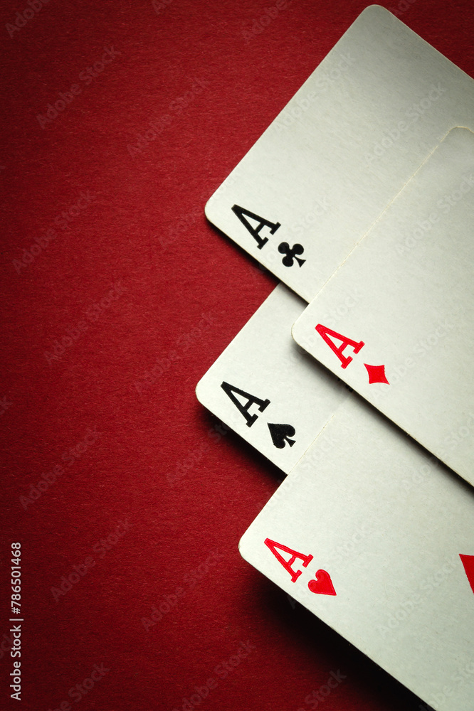 Obraz premium A winning playing card combination of four aces in poker or four of a kind or quads. Concept of luck or fortune in casino game on red table. Space for advertising