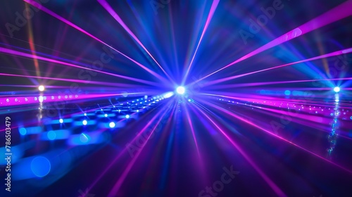 Intense laser light in blue and violet hues shines across a dark background