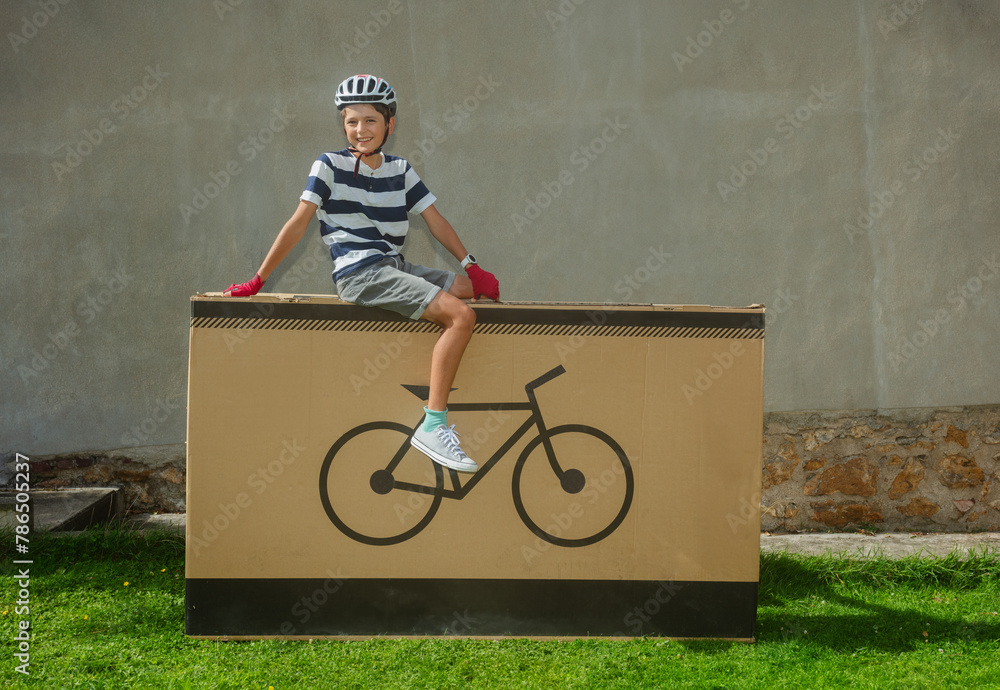 Grinning teenager cyclist posing on large bike-icon package - obrazy, fototapety, plakaty 