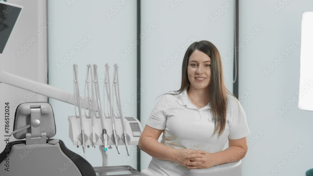 With an expression of benevolence and confidence, the dentist in the dental office looks at the camera and smiles, which conveys positive energy and confidence in his professional activity. With an expression of benevolence and confidence, the dentist in the dental office looks at the camera and smiles, which conveys positive energy and confidence in his professional activity.