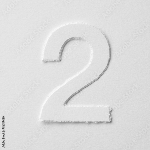 The number two is made of white paper on a white background.