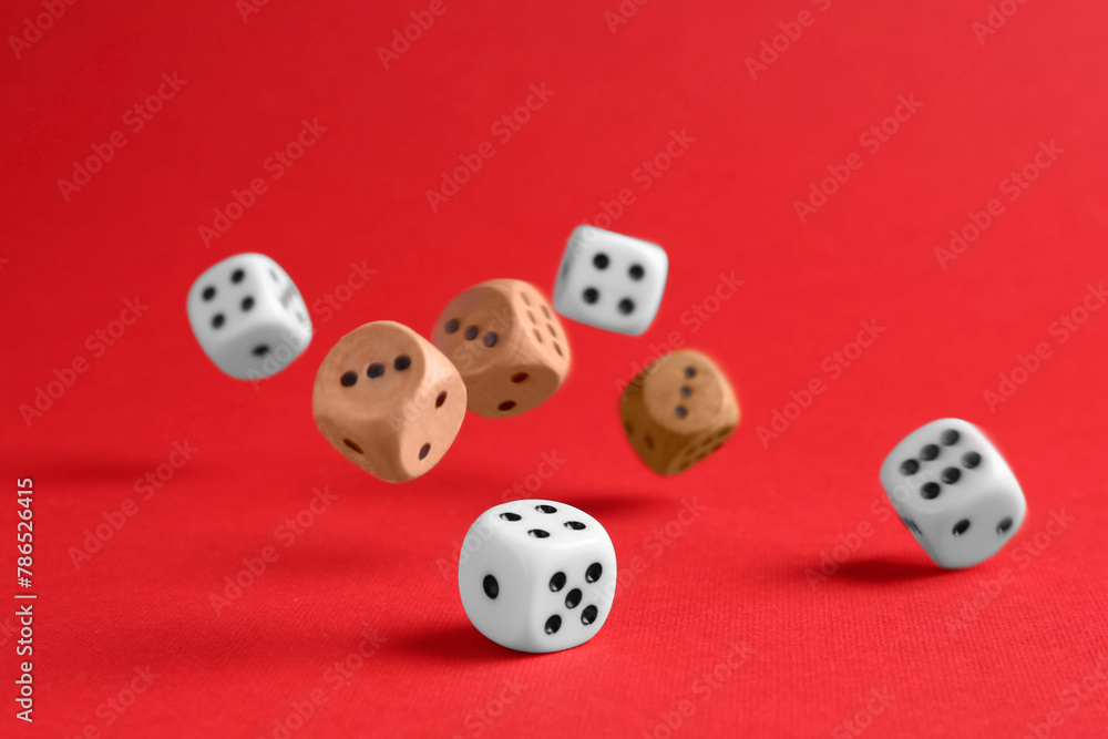 Many color game dices falling on red background Many color game dices falling on red background