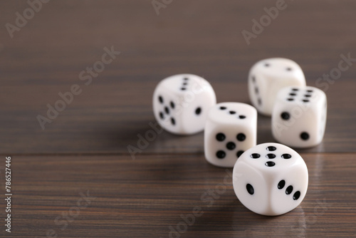Many white game dices on wooden table  closeup. Space for text
