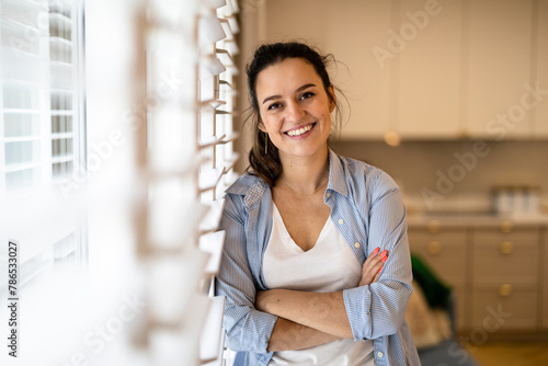 Portrait of a beautiful young woman standing in the kitchen at home
