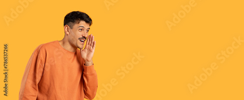 Konstfotografi Man whispering a secret on orange background