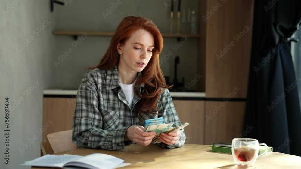 Portrait of sad young unemployment woman counting remaining money sitting at home table due to economic financial crisis. Empty wallet. Bankrupt, poverty, tax, money concept. Shooting in slow motion. Portrait of sad young unemployment woman counting remaining money sitting at home table due to economic financial crisis. Empty wallet. Bankrupt, poverty, tax, money concept. Shooting in slow motion.