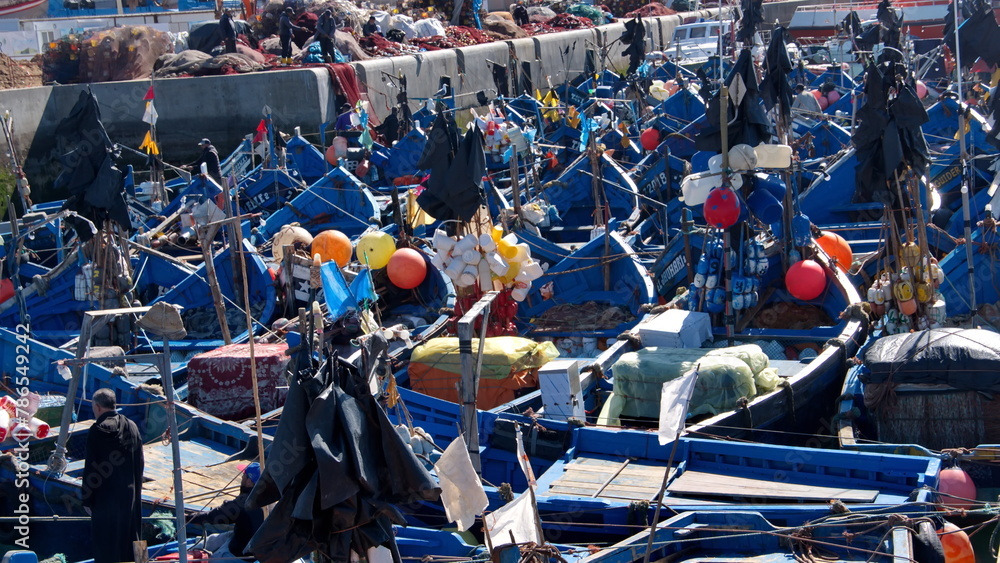 Fishing boats, with colorful floats for the fishing nets, moored in the marina at the port in Essaouira, Morocco - obrazy, fototapety, plakaty 