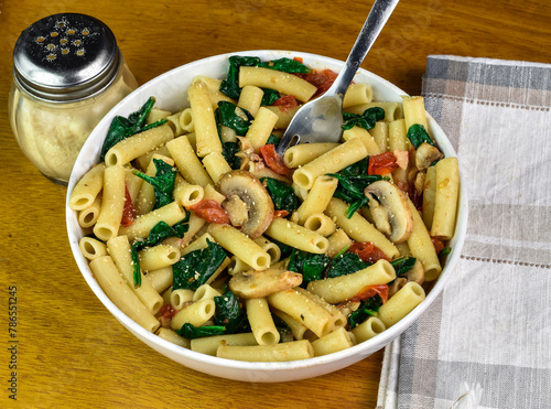 ziti mixed with mushrooms , tomatoes and spinach
