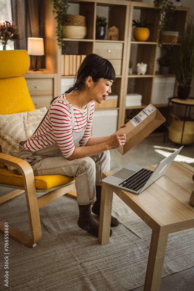 one japanese woman checking box of received package or product at home one japanese woman checking box of received package or product at home