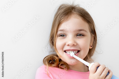 Caucasian child girl cleaning her teeth with electric toothbrush,dental concept, beautiful kid  smile. © nys