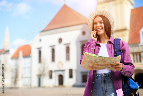 Woman with map and phone in European city © Prostock-studio