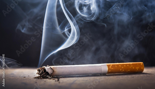 Cigarette with ash and smoke on dark background. World No Smoking Day
