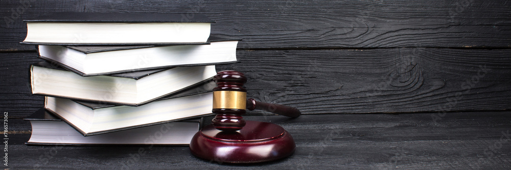 Law concept - Open law book with a wooden judges gavel on table in a courtroom or law enforcement office isolated on white background. panorama, banner. Law concept - Open law book with a wooden judges gavel on table in a courtroom or law enforcement office isolated on white background. panorama, banner.
