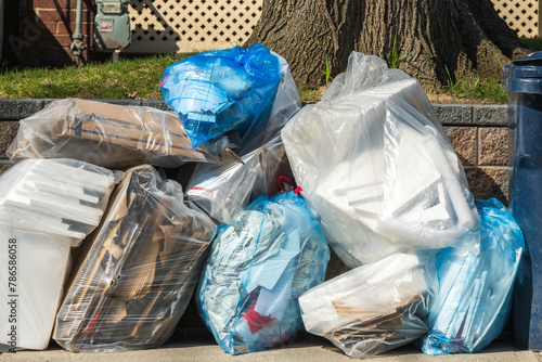 recycling pick up day: seperated materials in see through plastic bags await collection on a city sidewalk in a residential neignbourhood shot in the toronto beaches photo