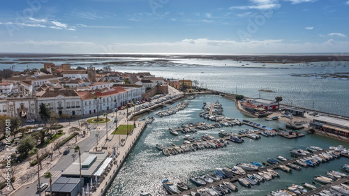 Traditional Portuguese town of Faro on oceanfront with old architecture, filmed by drone. Ria formosa and docs in background.
