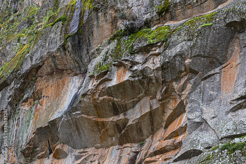 raw rock formation with minerals in orange, gray and green tone photo