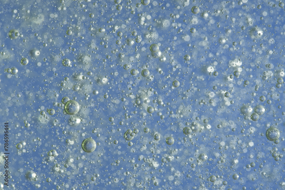 Fototapeta premium Bubbles in the water on a blue background. Closeup.
