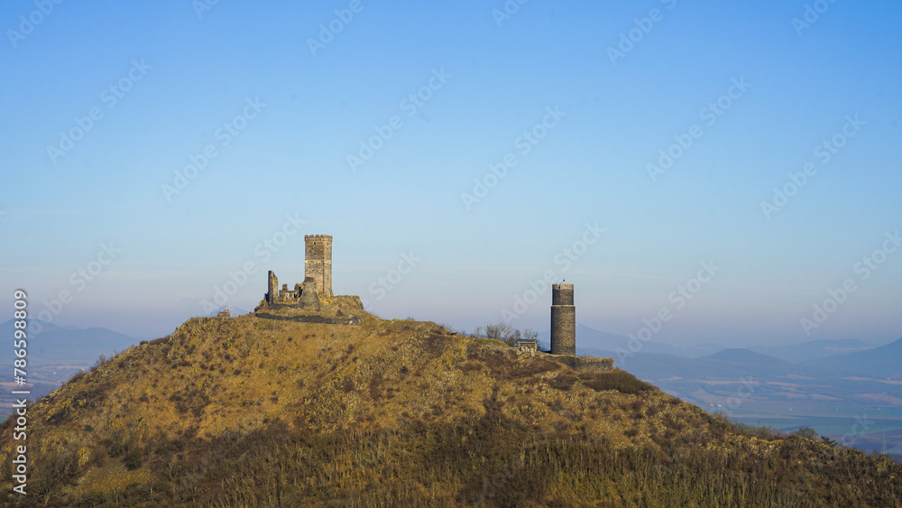 Hazmburk Castle ruins standing on a hill with clear blue sky in the Czech countryside