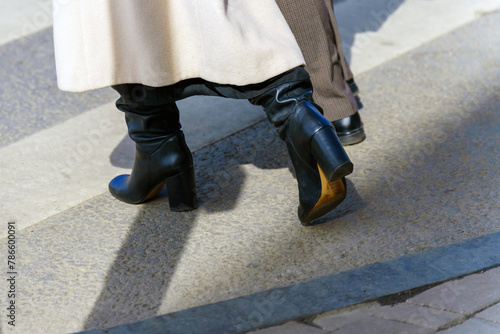 A woman's legs cross a pedestrian crossing