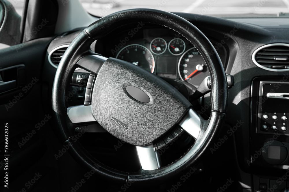 Black steering wheel and dashboard in car Black steering wheel and dashboard in car