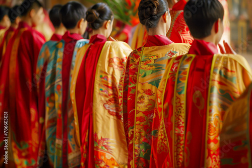 A group of people wearing red and gold robes with dragons on them
