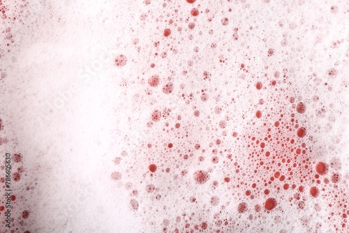 White foam with bubbles on red background, above view