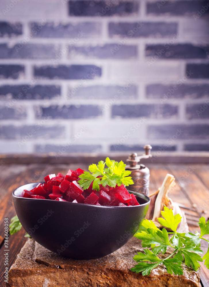 Beetroot salad with parsley in bowl on rustic wooden table.