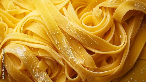 Close-up view of fettuccine pasta dusted with flour arranged in a dynamic composition on a vibrant yellow background.