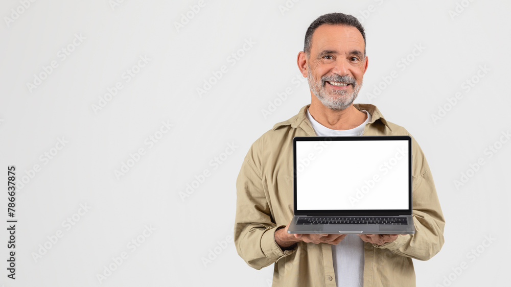 Senior holding a laptop with a blank screen Senior holding a laptop with a blank screen