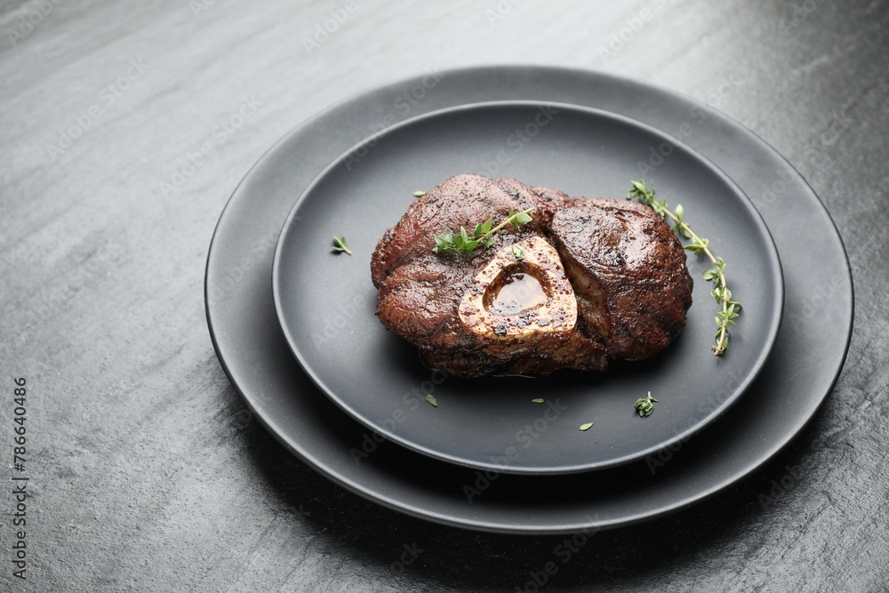 Delicious roasted beef meat with thyme on black table Delicious roasted beef meat with thyme on black table