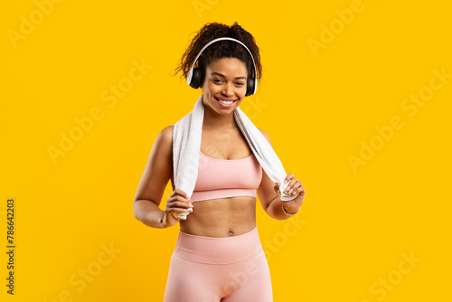 Cheerful african american lady with headphones and towel © Prostock-studio