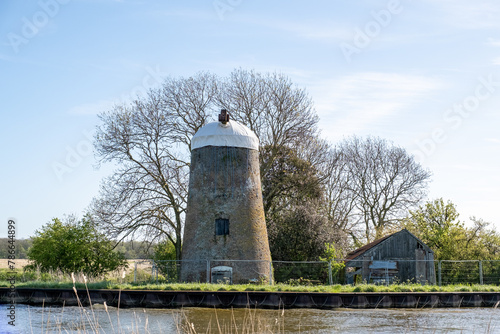 Old, disused and abandoned drainage mill on the bank of the Bure River in the heart of the Norfolk Broads